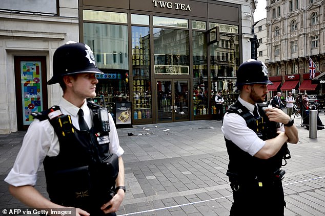 Police officers stand outside the cordoned off area in Leicester Square in London yesterday