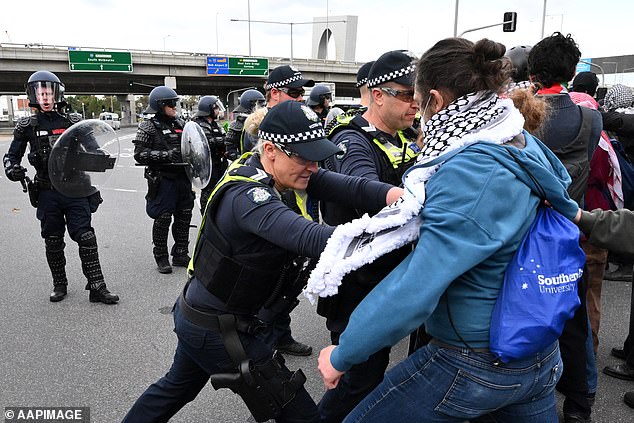 Victoria Police clash with protesters during a rally against the LandForces International Land Defence Exposition at the Melbourne Convention and Entertainment Centre on Wednesday