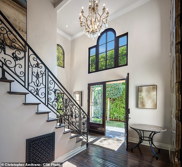 The entrance to the house is via a staircase and has a chandelier above the head