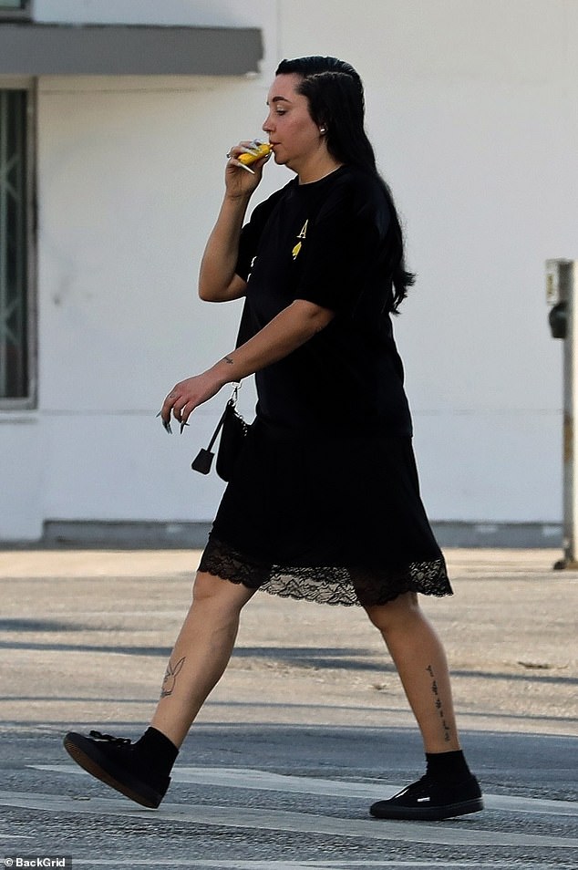 For her walk, she looked effortlessly stylish as she wore a T-shirt over a slip dress with a knee-length, lace trim. The Nickelodeon alum wore all-black sneakers with ankle socks