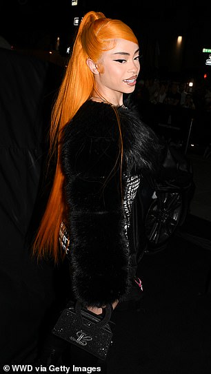 Her bright orange hair was worn half up, half down and she had on a glossy nude lipstick.