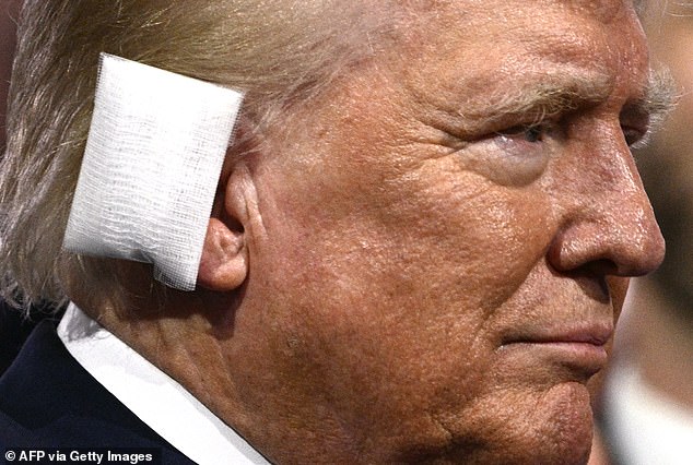 Former US President and 2024 Republican presidential candidate Donald Trump is seen with a bandage on his ear after being injured in an assassination attempt