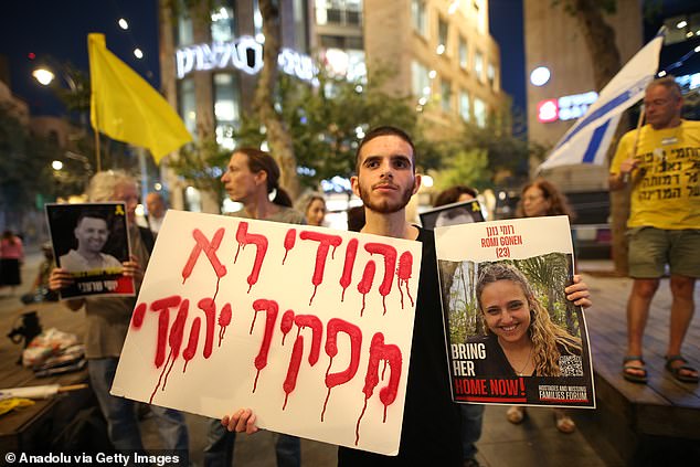 Pictured: A man in Jerusalem holds a photo of one of the Israeli hostages outside the US embassy