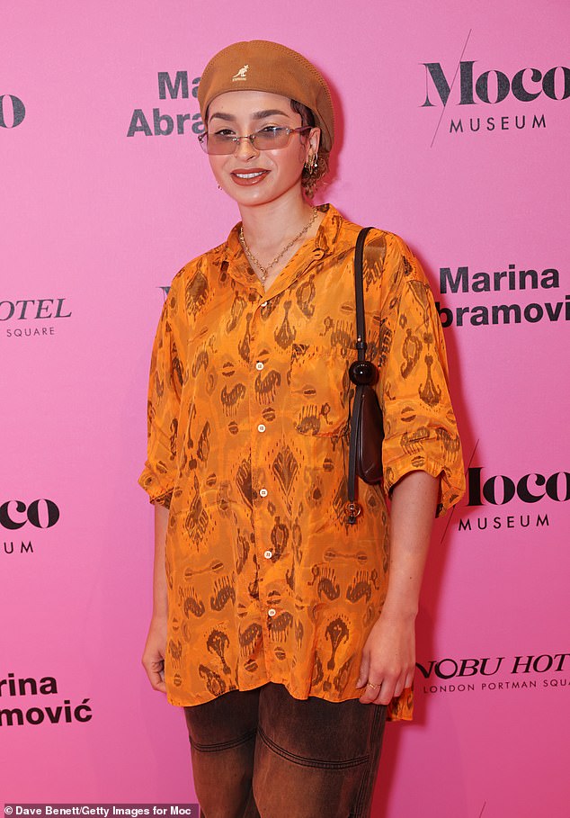 She accessorized with a beret, rectangular sunglasses and a pair of square loafers, and carried her belongings in a black handbag