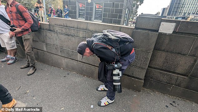 Herald Sun photographer Jake Nowakowski curls up in pain after being gassed by police