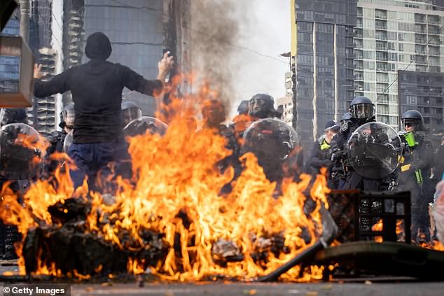 Melbourne streets burn as lone protester stands in front of police line