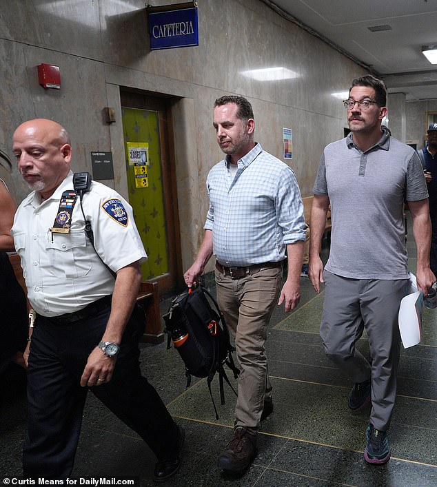 Wicks (right) walks out of court with his husband on Tuesday after his arraignment in Manhattan Superior Court.