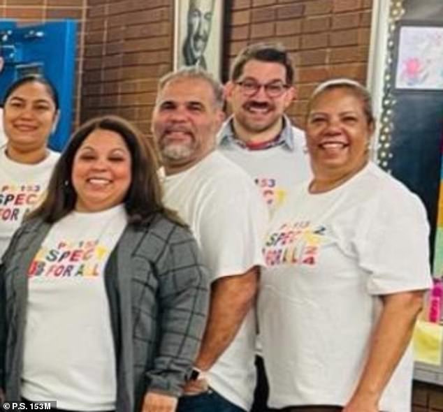 Wicks (center) stands on the school's website, smiling next to a group of teachers and administrators