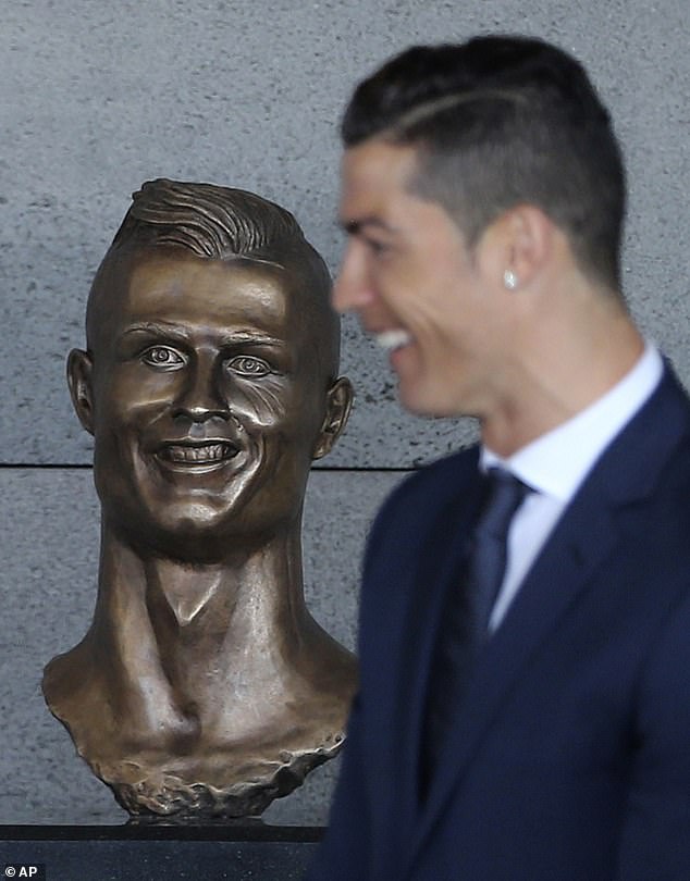 Cristiano Ronaldo stands next to a bust of himself at Madeira airport in 2017