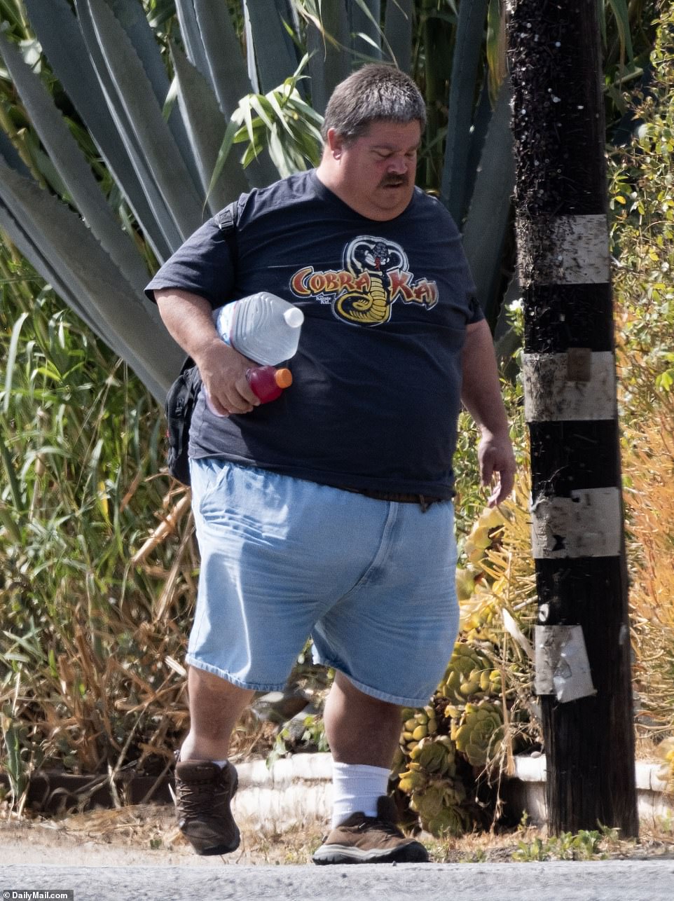 Jess reportedly became homeless and destitute after the trust fund he inherited from his mother ran out in 2011. He is pictured walking home from work last week during the Southern California heat wave with a gallon of water and Gatorade in hand.