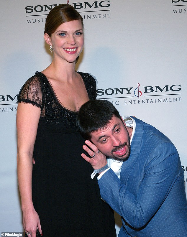 Dave appears to be listening to his unborn daughter with his wife Jordyn Blum at the 2006 Grammys