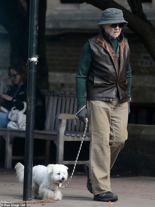 The Simply Red star looked out of place in his suburban surroundings in a dark green top and plain chino trousers as he walked his little dog Pip