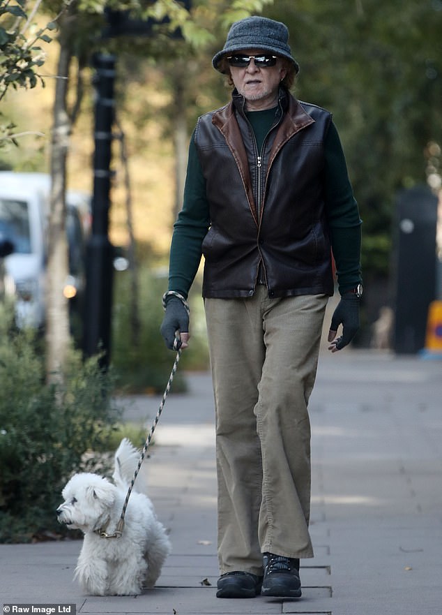 Mick completed his look with a pair of heavily tinted sunglasses and a pair of fingerless gloves as he took his dog for a solitary walk on Wednesday