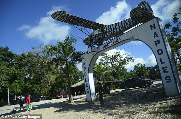 People pose for photos at the entrance to the Hacienda Napoles theme park, once the private zoo of drug lord Pablo Escobar on his ranch in Napoles