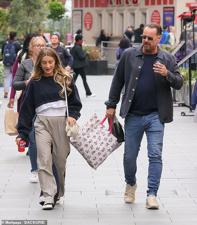 The influencer also wore beige striped pants and black shoes and added a cream handbag to her look