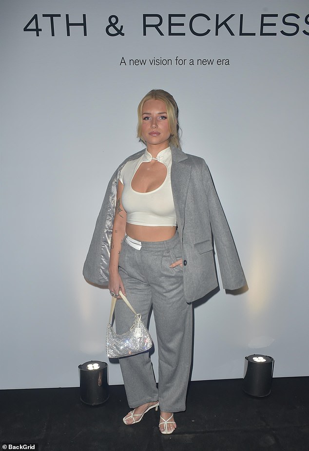 She paired the figure-hugging piece with high-waisted gray pants and draped a matching jacket over her shoulders