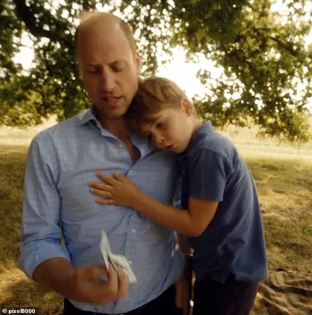 Prince Louis embraces his father, Prince William, as the family plays card games