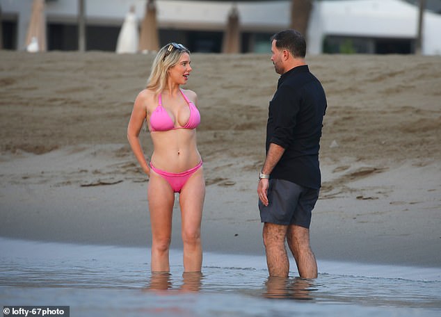 The couple couldn't keep their hands off each other as they enjoyed a dip in the sea during their first holiday together in August