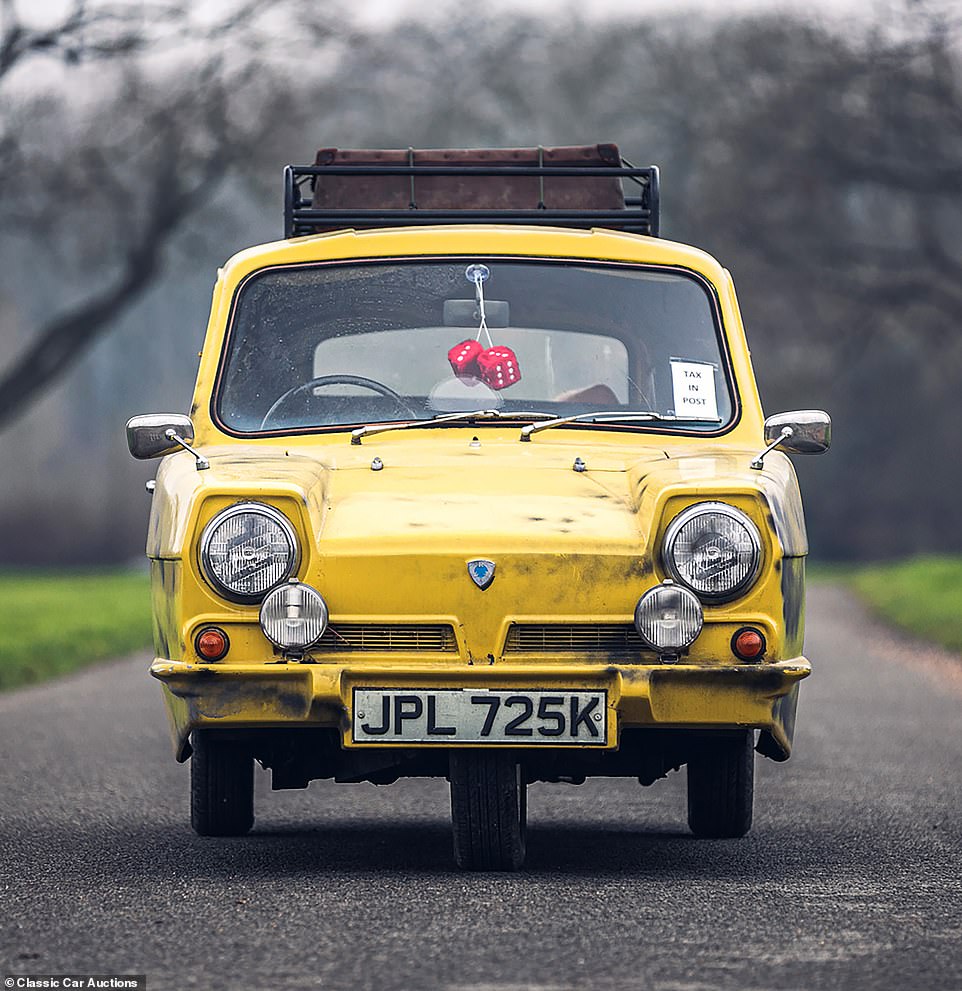 Included in the sale are fluffy dice, a 'Tax in Post' sign on the windshield and a roof rack with a market trader's suitcase on it