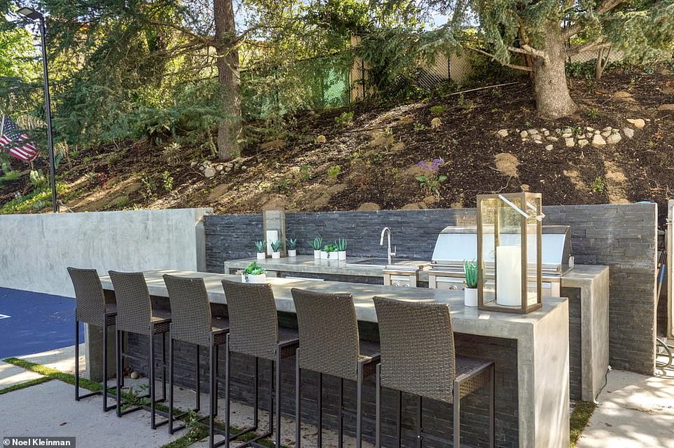 Between the house and the pickleball court is an outdoor bar ideal for entertaining all year round, as well as an open terrace that currently houses a long dining table