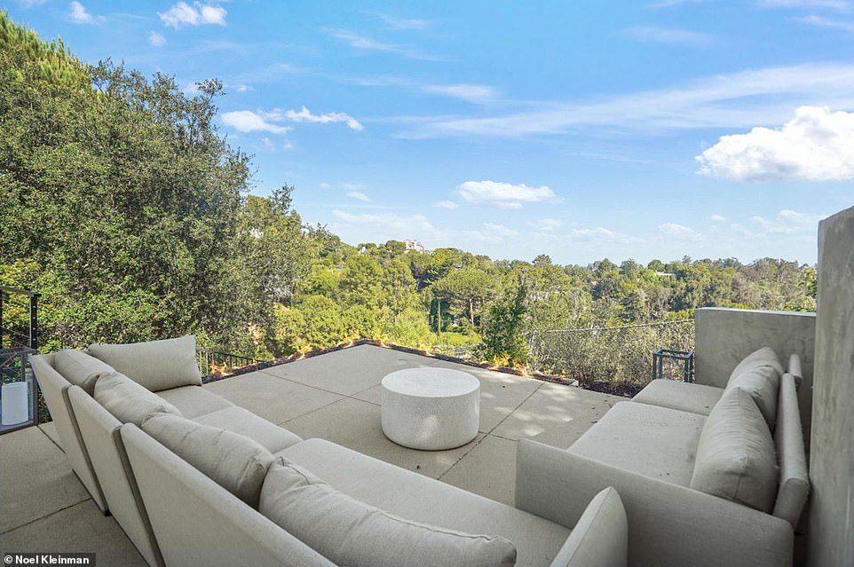 The concrete covered backyard features seating areas where you can relax with friends or simply enjoy the pristine views