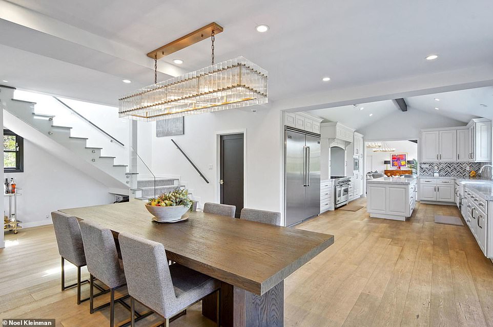 Directly next to the kitchen is a dining area with a beautiful, old-fashioned rectangular chandelier