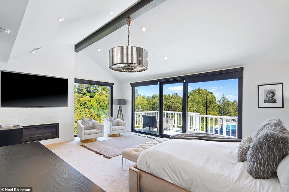 The master bedroom in the corner has even more fantastic views with large sliding glass doors and features a recess in the wall for a large television, along with a sleek fireplace that would be perfect for chilly evenings.