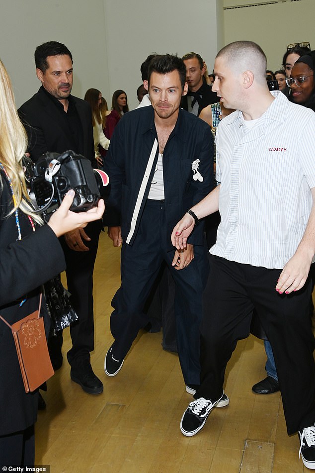 He completed his look with a pair of black and white Vans and wore a necklace