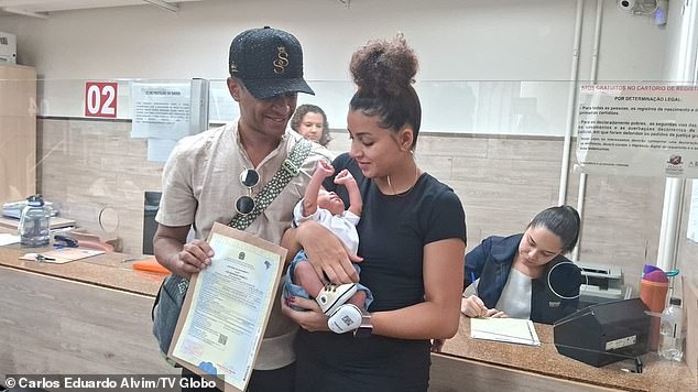 Danillo Prímola and his wife Catarina Prímola pose with their son's birth certificate