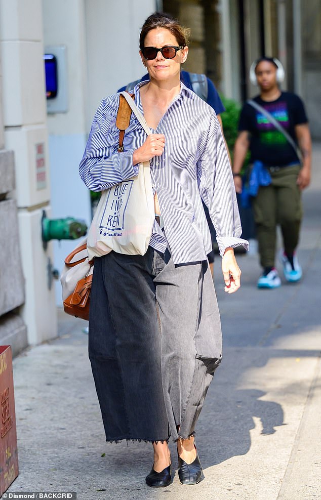 Holmes' long, dark hair was pulled back into a loose bun and her makeup looked natural behind black-framed sunglasses