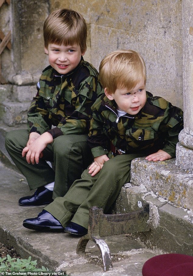 Prince Harry and Prince William sit together on the steps of Highgrove House, dressed in army uniforms, in July 1986