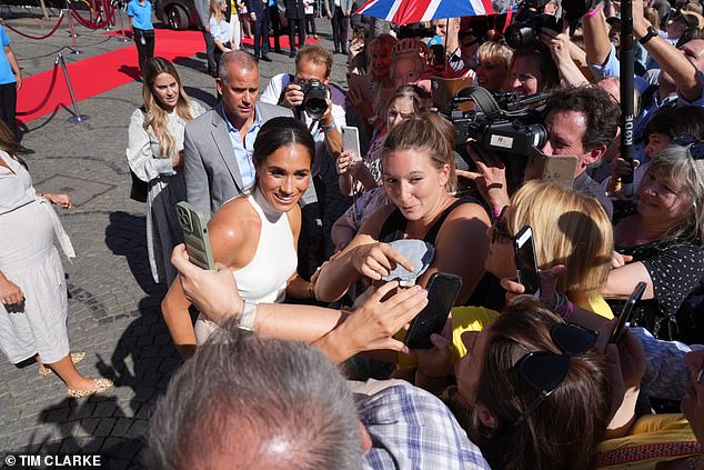 He's a ubiquitous force at the Sussexes' engagements, seen here behind Meghan at a 2022 Invictus Games launch event in Dusseldorf, Germany