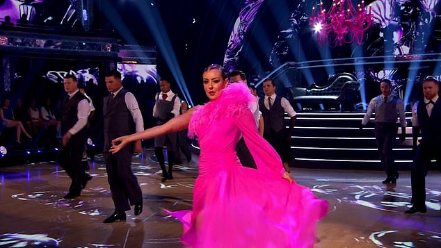 Amy was a vision in a dazzling fuchsia ball gown with feather embellishments, twirling as she showed off her incredible moves