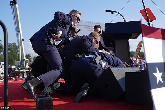 Trump, pictured here surrounded by Secret Service agents, recovered from his injuries and appeared at the Republican National Convention two days later