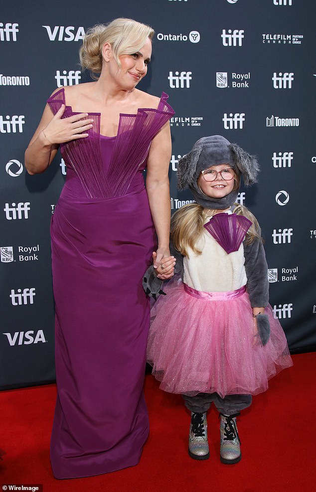 The form-fitting dress clung to her slender frame as she confidently walked and posed for the cameras; pictured with eight-year-old Australian actress Scarlett Crabtree, who stars in The Deb