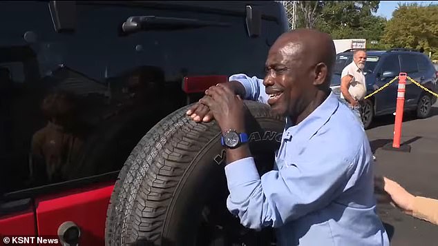 He is seen wrapping his arms around the giant tire as one of the boys pats him on the back