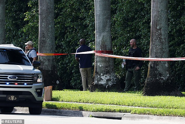 Police inspect the tree line and brush outside Trump International Golf Club, where the gunman hid and left his belongings as he fled the scene