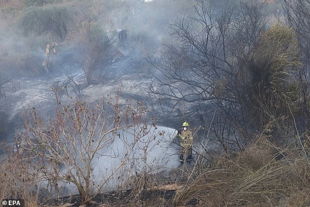 A firefighter extinguishes a fire that broke out after Houthis claimed to have fired a hypersonic missile