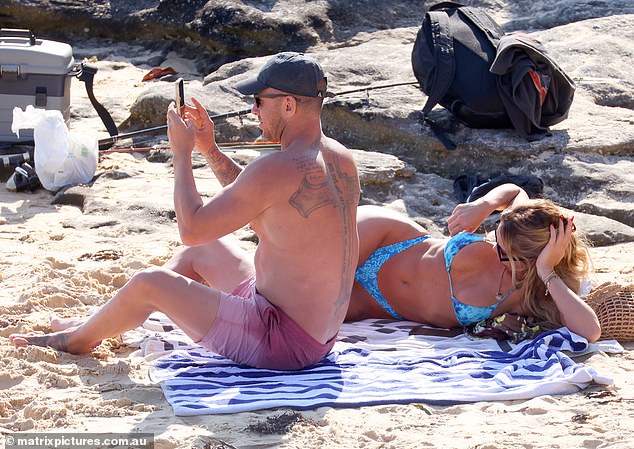 Meanwhile, her heavily tattooed boyfriend showed off his muscular and tattooed body in pink board shorts