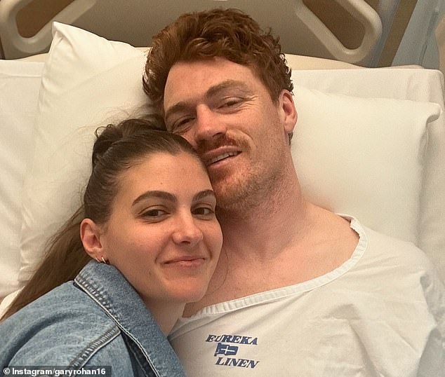 Rohan (pictured with wife Madi) posted a photo from hospital as he awaited surgery after suffering a horrific injury during a VFL match