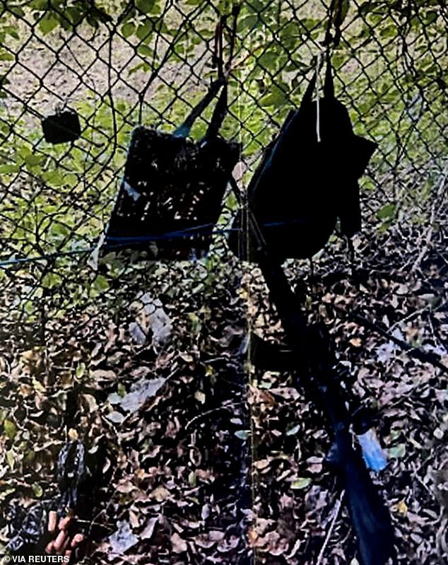 The shooter had an AK-style rifle with a scope, a GoPro camera and two backpacks hanging from a fence (pictured)