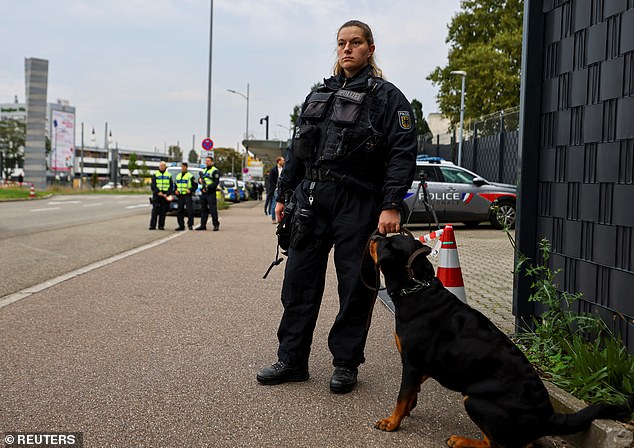 A German police officer stands guard next to a dog at the border with France on Monday