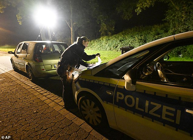 A police officer checks vehicles near the Belgian border in Aachen on Monday