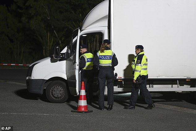 Police officers check a van at the Bunderneuland border crossing early Monday morning