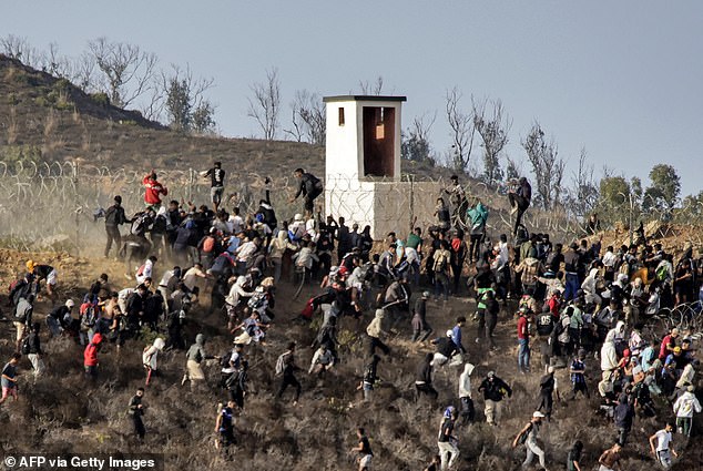 1726491364 516 Migrants storm EU border Hundreds swarm barbed wire fence after