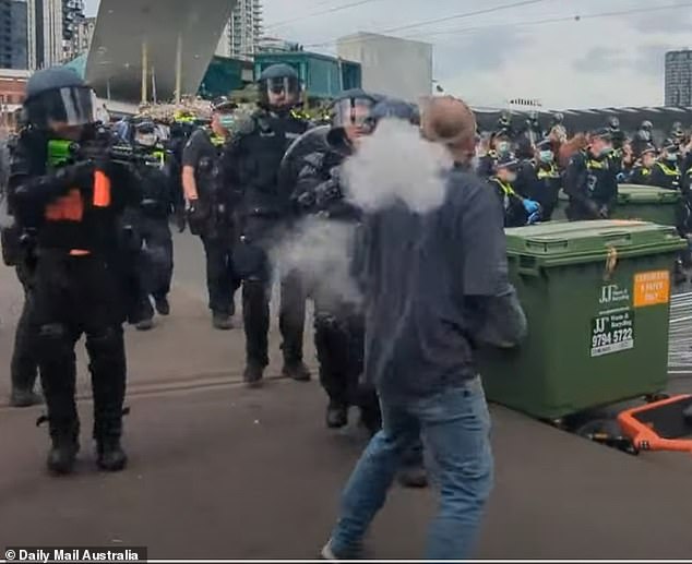 Police shoot at close range at a protester who was also doused with OC foam