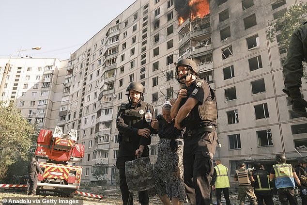 Firefighters assist an injured person after Russia hit a tall building in Kharkiv with a KAB-250 bomb with a UMPK module in Kharkiv