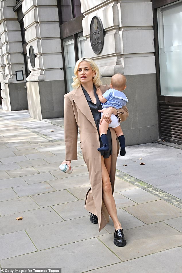 Sporting her usual peroxide blonde locks, the new mom wore a floor-length camel coat over a cropped suit