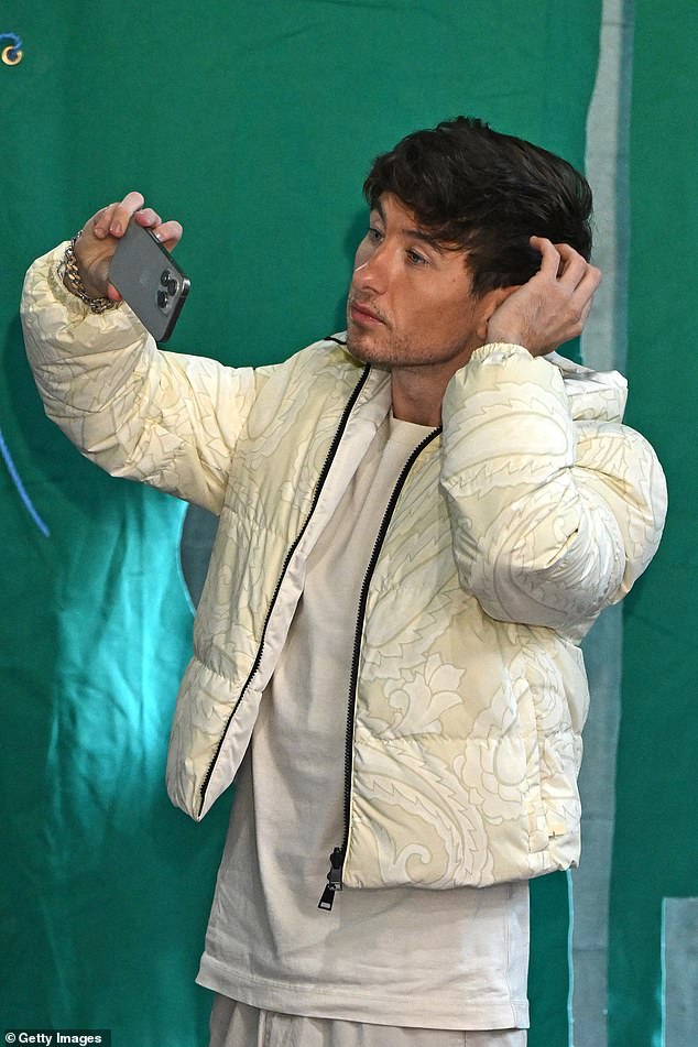 The Saltburn star wore a cream puffer jacket with an intricate pattern over a plain white T-shirt and wide grey trousers