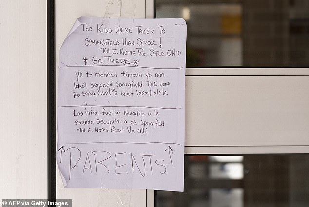 A note on the door of Fulton Elementary School telling parents where to pick up their children after a bomb threat